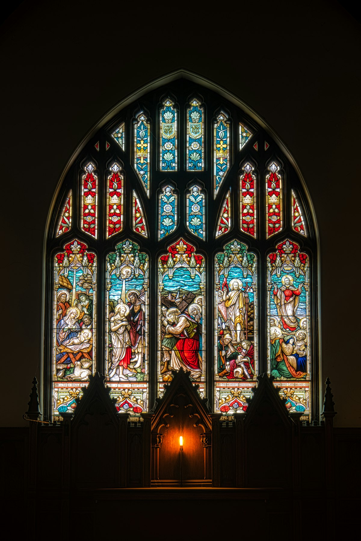 A detailed religious stained glass window inside the church